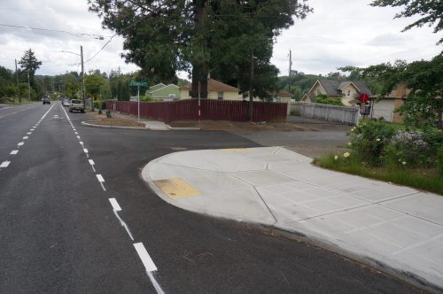 Photo showing a newly installed curb bulb and ramp with federal yellow tactile domes.
