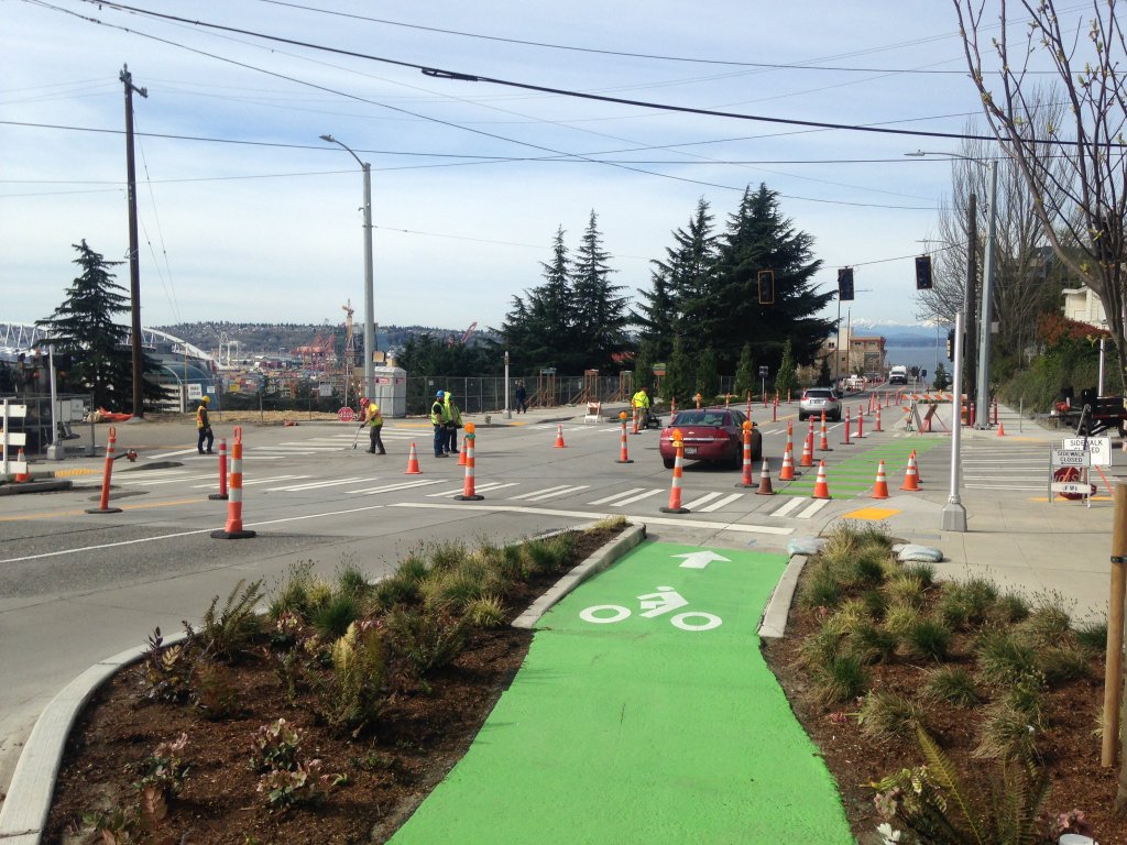 Photo of protected bicycle lane on Yesler drops down to street level at the intersection.